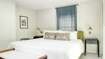 A neatly arranged bedroom with a bed, bedside tables, and a framed picture on the wall.