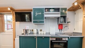 Una cucina moderna con mobili verdi, un forno Bosch e una lavastoviglie Siemens.