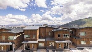 A modern wooden building with multiple units, large windows, and a view of mountains. - Slopewatch by Avantstay Ski-in/out Luxe Retreat (Park City)