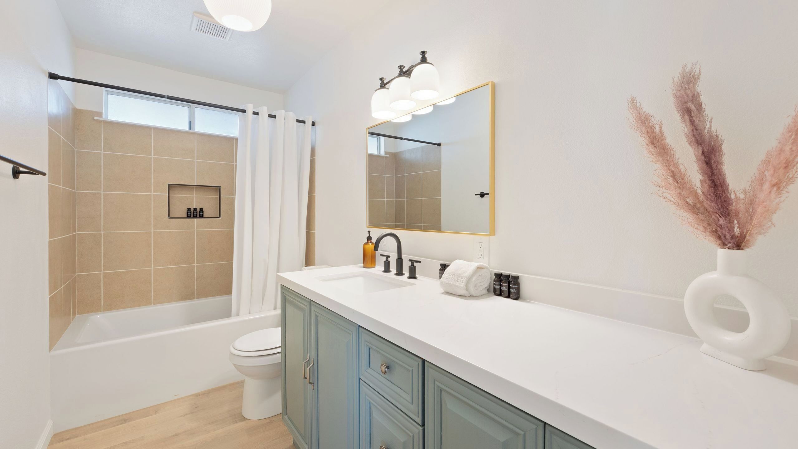 A modern bathroom with a bathtub, toilet, and vanity.