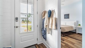 A room with a bed, a wall-mounted drying rack, and a view of the outside.