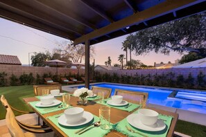 An outdoor dining area with a pool, green tablecloths, and chairs. - Casa Nueva: 4 bedroom Pool, Spa, Games, close to Polo (Indio)