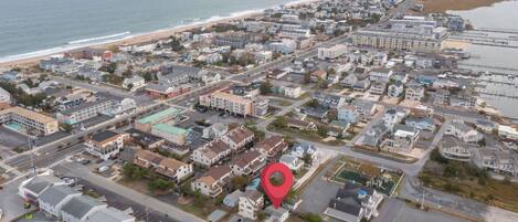 An aerial view of a coastal town with a red location marker.