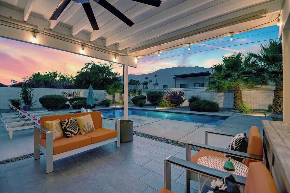 An outdoor patio area with a pool, seating, and a view of the mountains.