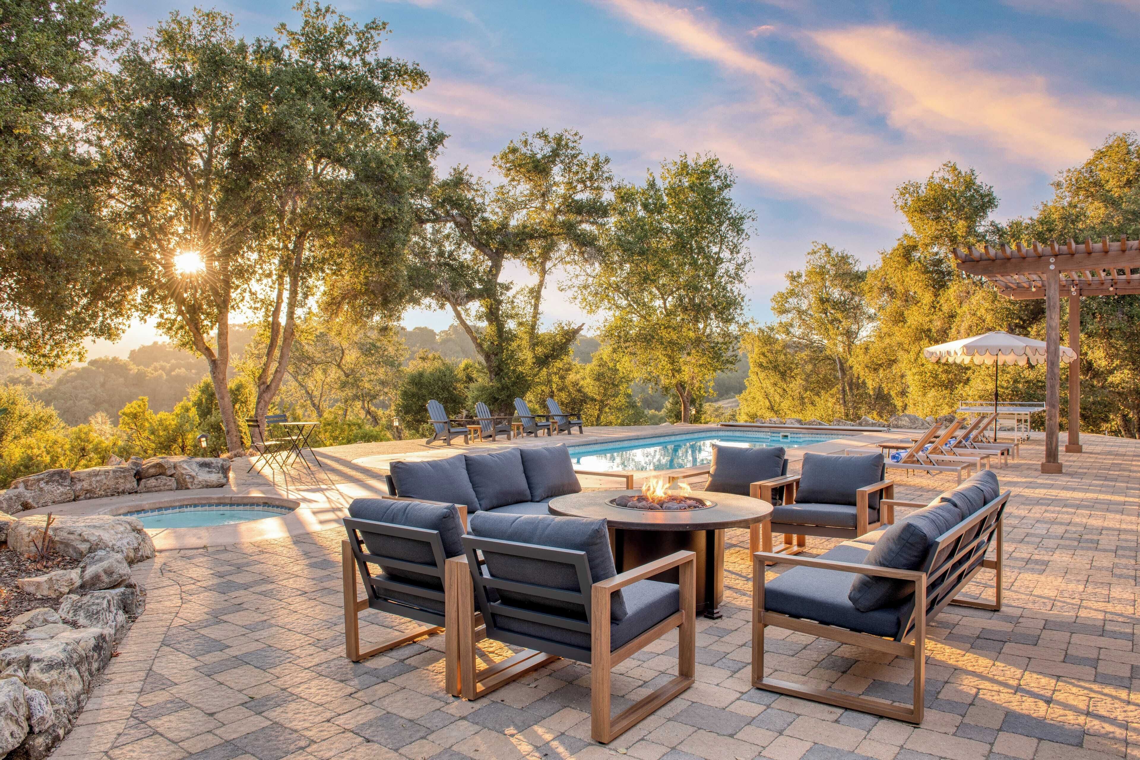 A poolside area with outdoor seating and a pergola.