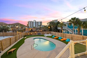 A backyard with a swimming pool, wooden deck, and outdoor seating. - Tidepool by Avantstay 2min Walk to Miramar Beach! (Miramar Beach)