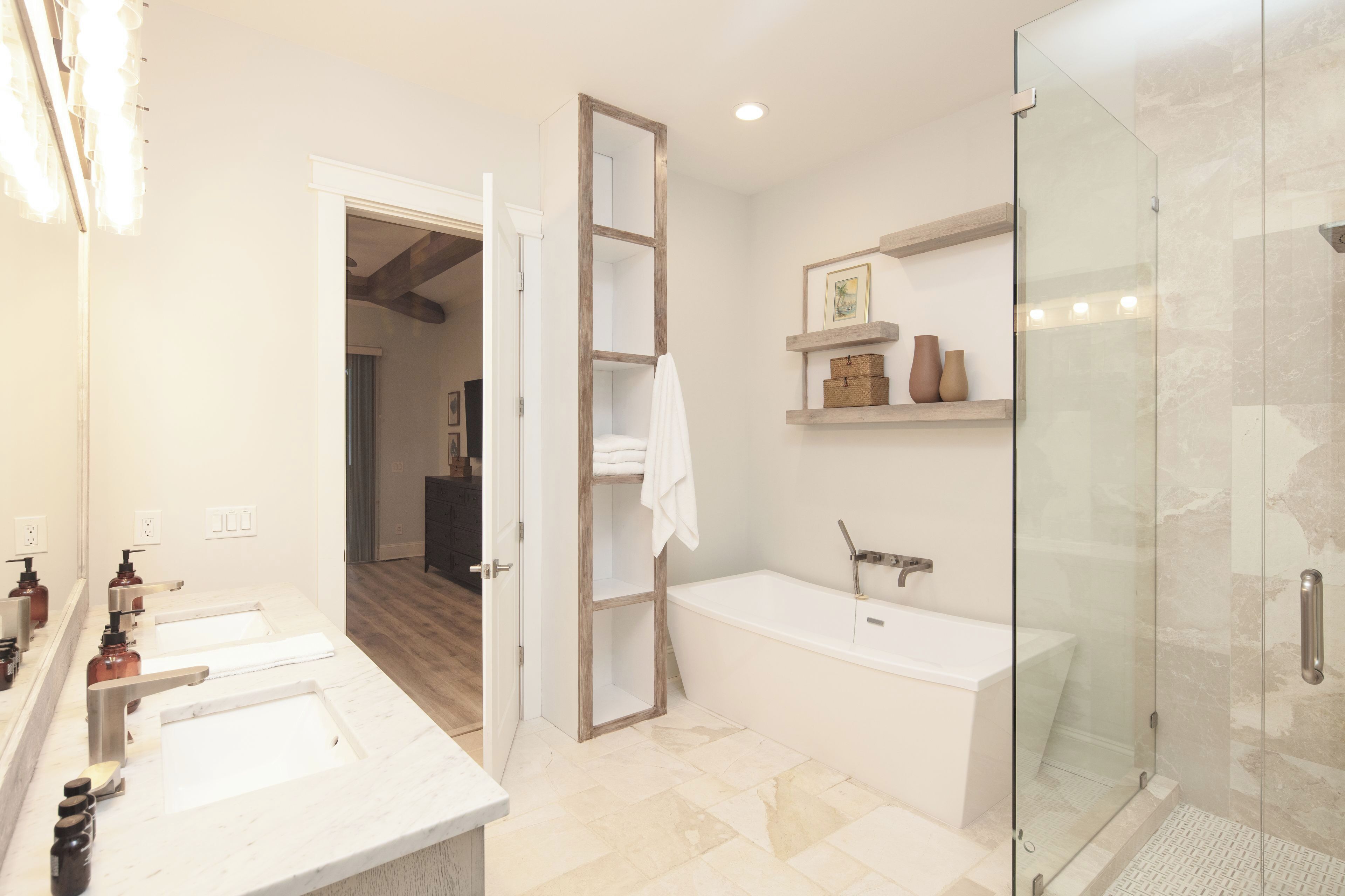 Un baño con cabina de ducha de vidrio, bañera y tocador con espejo.