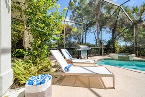 A pool area with lounge chairs, a barbecue grill, and a hot tub. - Miramar Manor by Avantstay Walk to the Beach! (Miramar Beach)