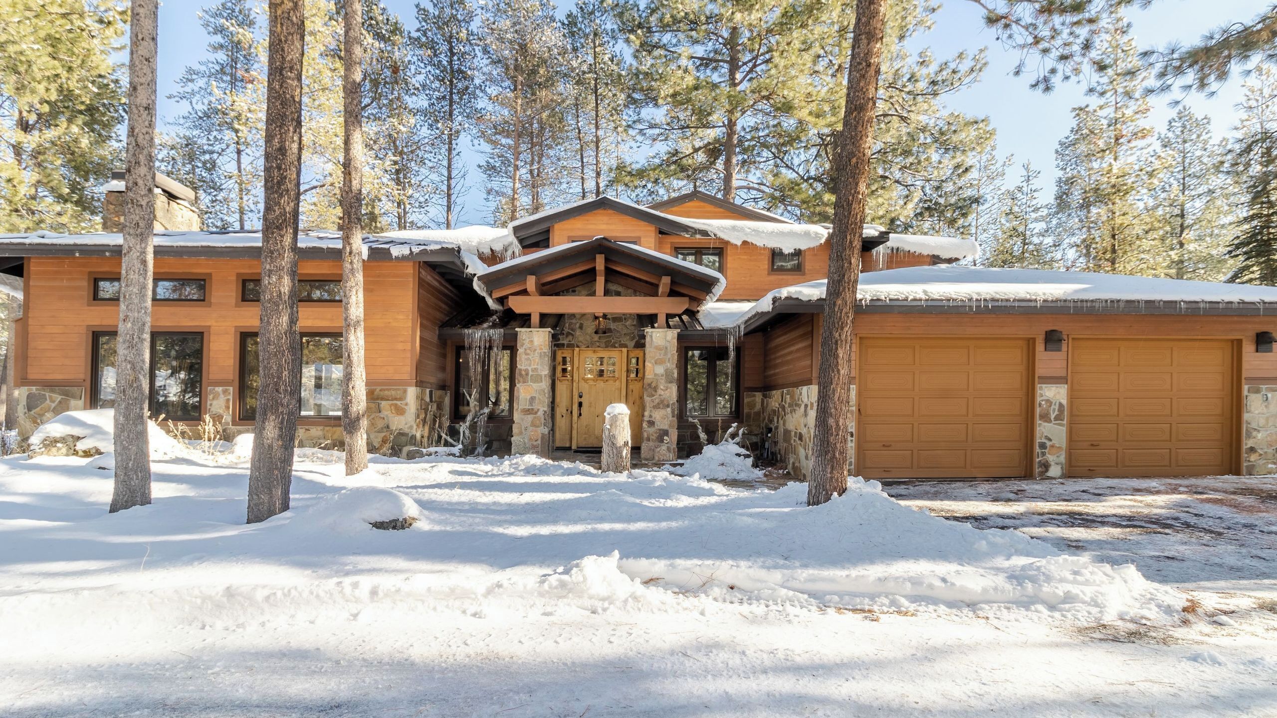 A lodge with a stone facade, wooden entrance, and a garage.