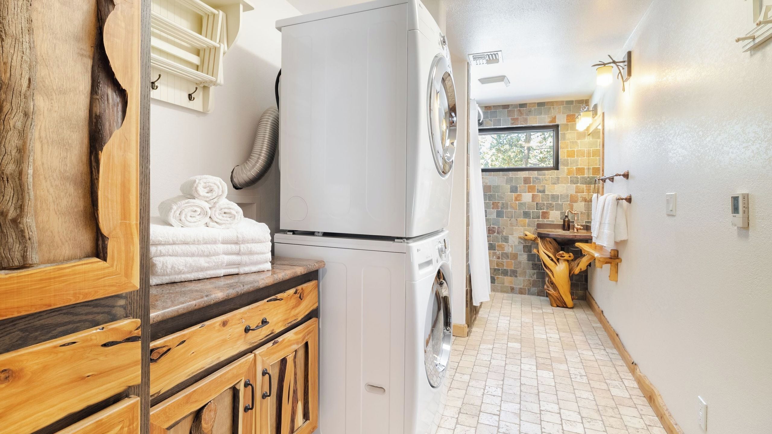 A laundry area with a washing machine, dryer, and wooden cabinets.