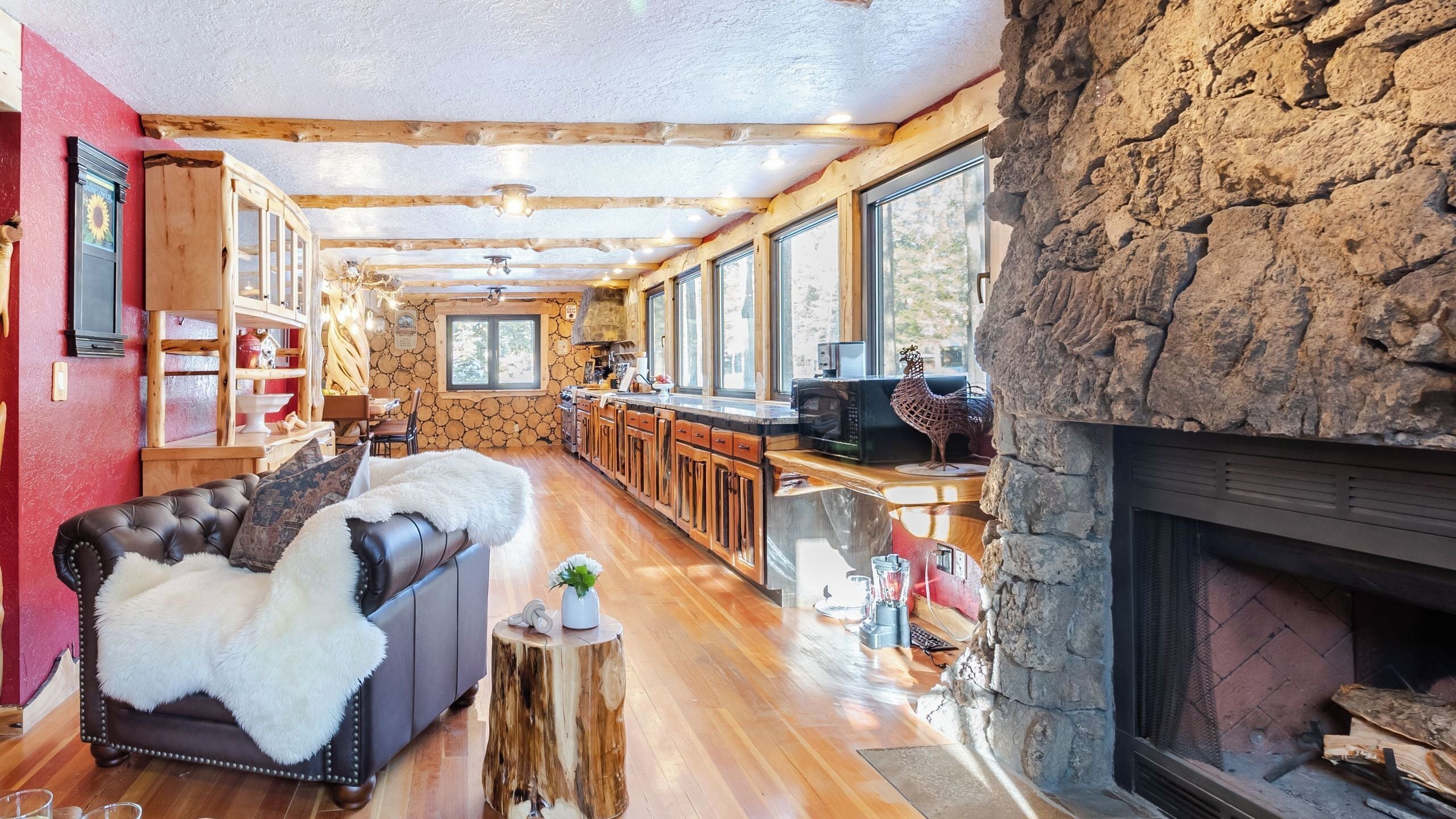 Ein gemütliches Wohnzimmer mit Kamin, Holzböden und einer Steinwand.