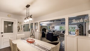 A spacious living area with a dining table, a fireplace, and a view of the outdoors. - Oasis with Heated Pool (Siesta key)