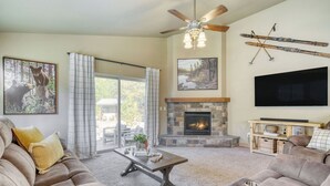 A living room with a fireplace, sofa, coffee table, and artwork. - Hot Tub, Air Hockey, Foosball, Deck Lounge Near Sunriver & Mt. Bachelor Skiing (Bend)