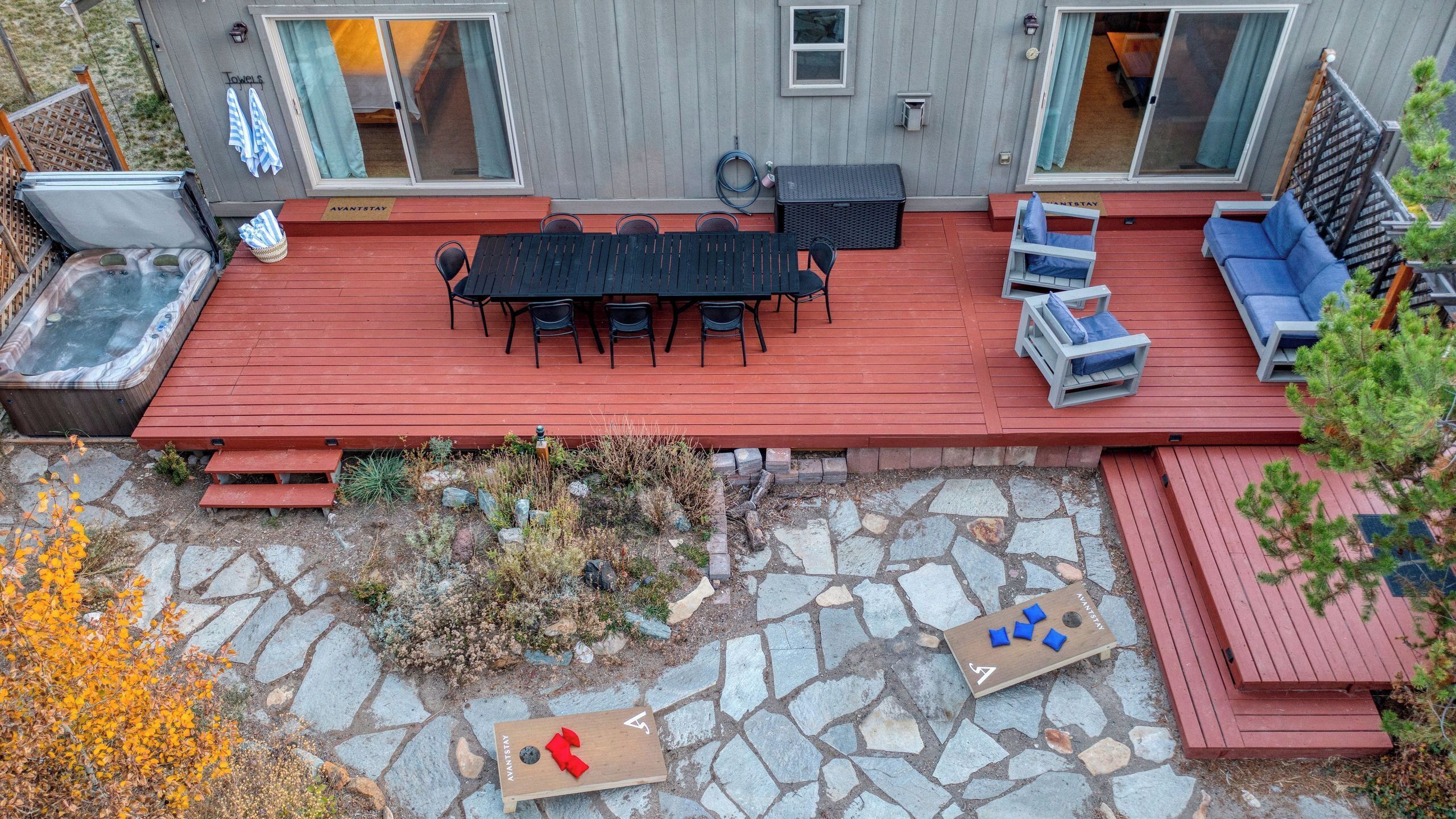 Eine Terrasse mit Tisch und Stühlen, einem Whirlpool und einer gepflasterten Sitzgelegenheit.
