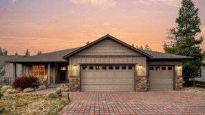 A two-story house with a garage, stone foundation, and a brick driveway. - Hot Tub, Air Hockey, Foosball, Deck Lounge Near Sunriver & Mt. Bachelor Skiing (Bend)