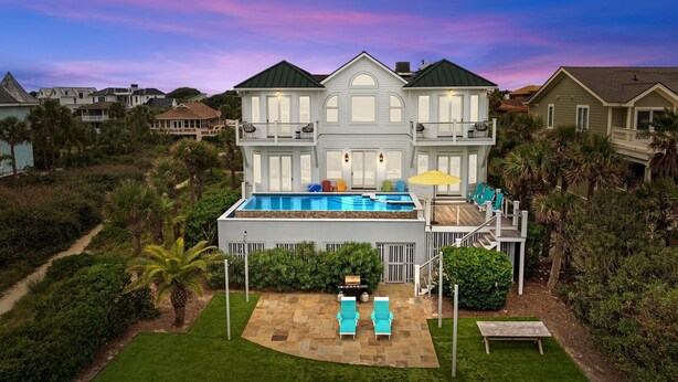 A large two-story house with a swimming pool, a deck, and a well-maintained lawn. - Luxury Oceanfront- Private Pool, Hot Tub, & Elevator! Can't beat location! (Isle Of Palms)