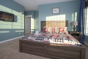 A bedroom with a bed, a nightstand, a lamp, and a door.