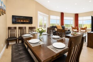 A dining area with a fireplace, a sofa, and a view of the outdoors.