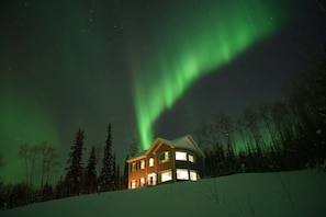 A house with a snow-covered roof and a visible window.
