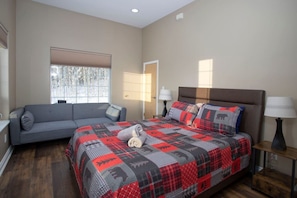 Un dormitorio con cama, sofá, ventana y puerta.