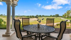 A covered patio with a round table and chairs, overlooking a golf course. - Centre Court Sunbeam: Free Water Park, Golf View, Pool, Near Disney (Kissimmee)