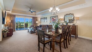A spacious living room with a dining area, large windows, and a ceiling fan. - Centre Court Sunbeam: Free Water Park, Golf View, Pool, Near Disney (Kissimmee)