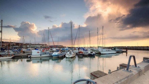 A marina with multiple boats docked, calm water, and a cloudy sky. - The Cote, Little Upton Farm (Ashey)