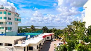 A hotel with a view of the sea, a parking area, and a building with a red roof. - Renovated Studio in Cancun Beach (Cancún)