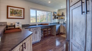 A kitchen with wooden cabinets, a large window, and a refrigerator. - Saddleback - Rock Pond Condo 24 - right above base lodge (Rangeley)