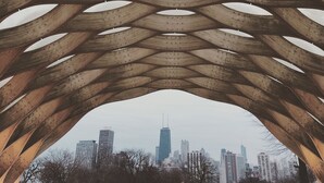 Een moderne architecturale constructie met een geometrisch patroon van elkaar kruisende houten balken.