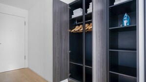 A walk-in closet with dark wood doors, shelves, and hanging space.