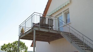 Un bâtiment doté d’un balcon, d’un escalier et d’une fenêtre.