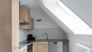 Une cuisine dotée d’une lucarne, d’un lave-vaisselle et d’une cuisinière.