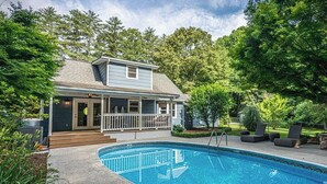 Une maison avec une piscine, une véranda et une cour clôturée.
