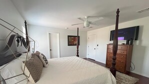 A bedroom with a four-poster bed, a ceiling fan, a dresser, and a television on the wall. - Top Location! Spacious Home Near Downtown & Events (Austin)