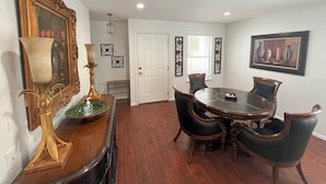 A dining area with a round table, four chairs, a decorative lamp, and a framed painting on the wall. - Top Location! Spacious Home Near Downtown & Events (Austin)