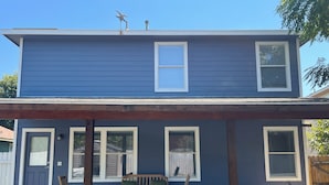 A two-story house with a covered porch, a wooden bench, and a rocking chair. - Top Location! Spacious Home Near Downtown & Events (Austin)