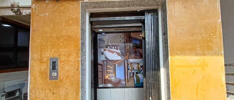 The entrance to Hotel Leela Palace's 3rd floor, featuring an elevator and a glass door.