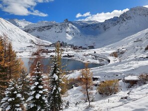 Escape to a serene alpine setting surrounded by snow-covered mountains and a tranquil lake.