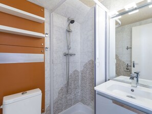 Bathroom features a shower enclosure with a glass door and patterned tile design.