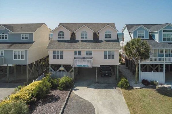 A row of two-story houses with a central driveway and a small front yard.