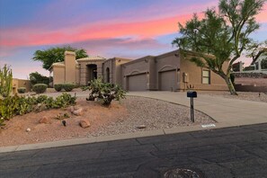 A residential building with a curved driveway, a mailbox, and a well-maintained garden with cacti and shrubs. - Hillside Tranquility - Desert Views, Heated Pool, Outdoor Kitchen & Light-Filled Luxury (Fountain Hills)