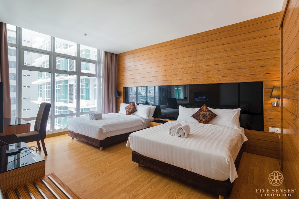 Ein Hotelzimmer mit zwei Betten, einem Schreibtisch und einem großen Fenster.