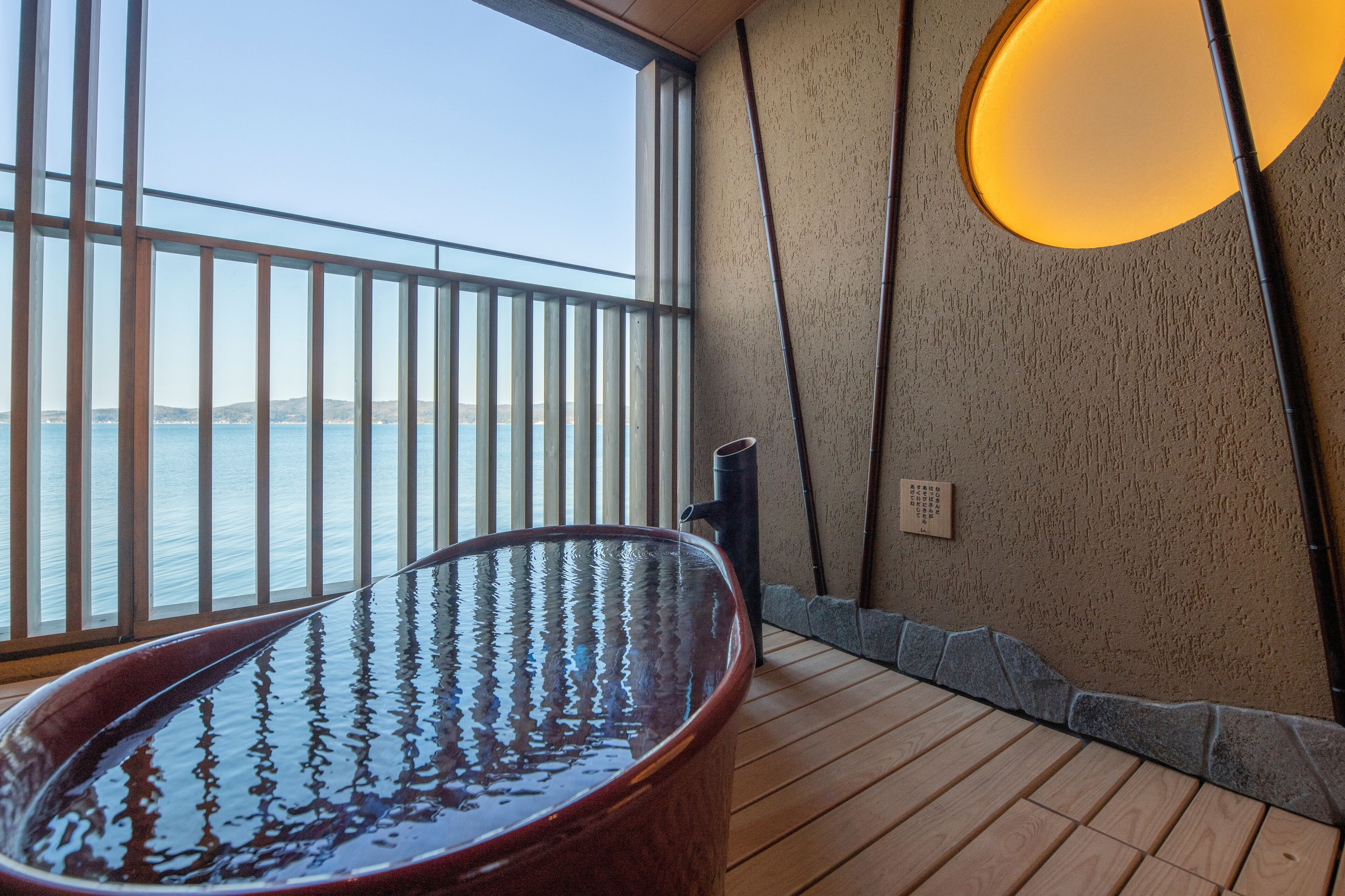 A spa area with a large hot tub, a view of the sea, and a modern interior design.