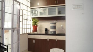 Una cocina con armarios de madera oscura, una planta en maceta y una cafetera.