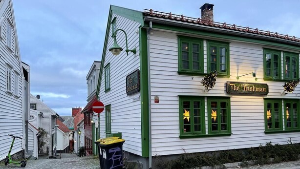 A building with a sign reading "The Irishman" on a cobblestone street. - Charming 2-Bed Apartment in Stavanger (Stavanger)