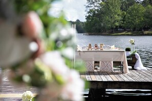 Une jetée en bois avec une table dressée pour un mariage.