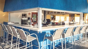 A bar area with a counter, seating, and a view of the interior. - Main Street in Paradise Palms (Kissimmee)