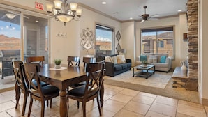 A spacious living area with a dining table, sofas, and a stone accent wall. - The View Resort Amenities & Epic Views! (Hurricane)