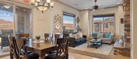 A spacious living area with a dining table, sofas, and a stone accent wall.